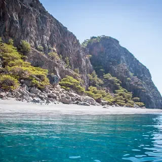 Falaises blanches plongeant dans des eaux turquoise limpides, offrant une vue spectaculaire sur la côte de Candia, Crète.