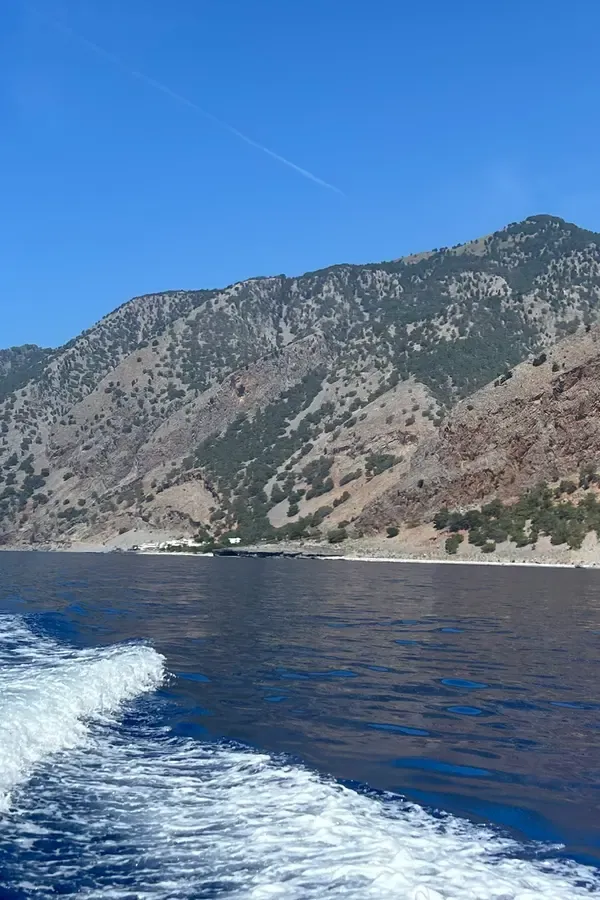 Agia Roumeli, village côtier de Crète, surplombant la mer Ionienne et les montagnes escarpées d'un fond marin bleu limpide.