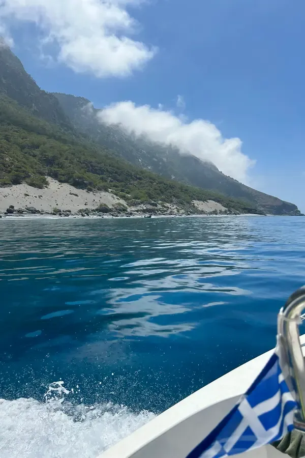 Vue panoramique de la baie d'Agios Pavlos, entre les falaises rocheuses et les eaux turquoise de la mer Égée.