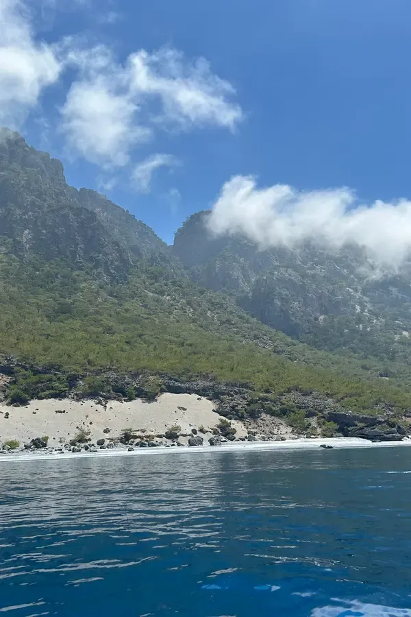 Vue pittoresque du village d'Agios Pavlos, avec ses maisons colorées et la baie bordée de sable fin.