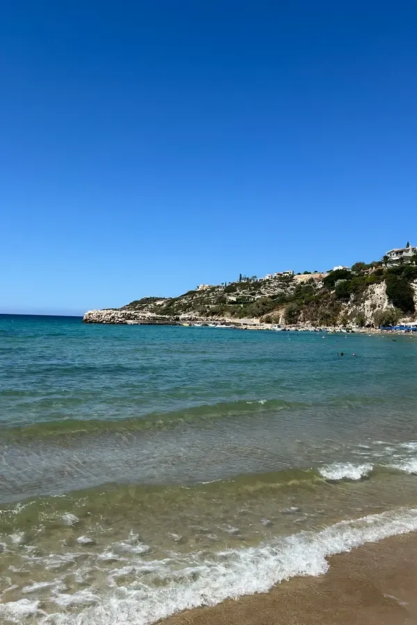 Clear turquoise waters meeting the rugged coastal landscape of Almyrida, Crete.