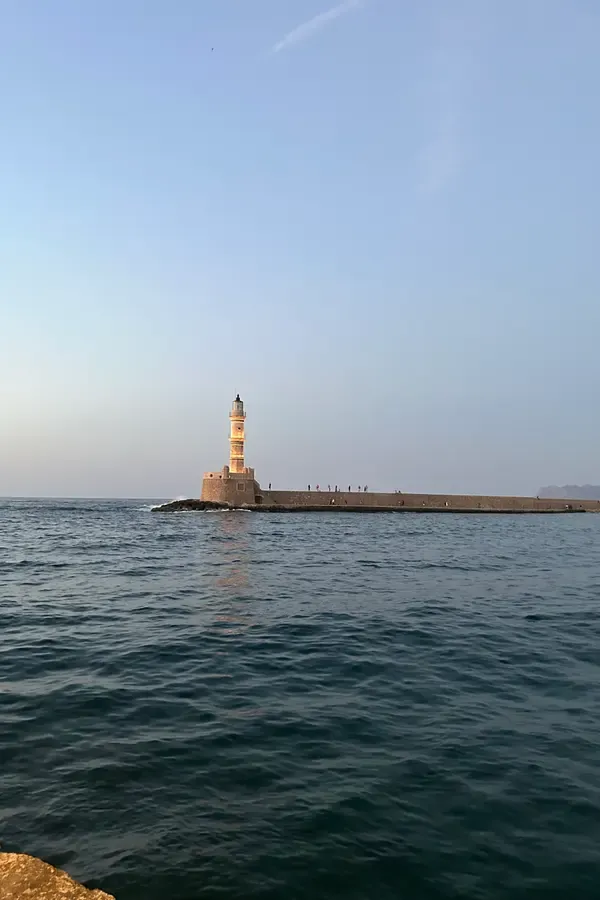 Historic Venetian harbor buildings viewed from the deep blue waters of Chania, Crete.