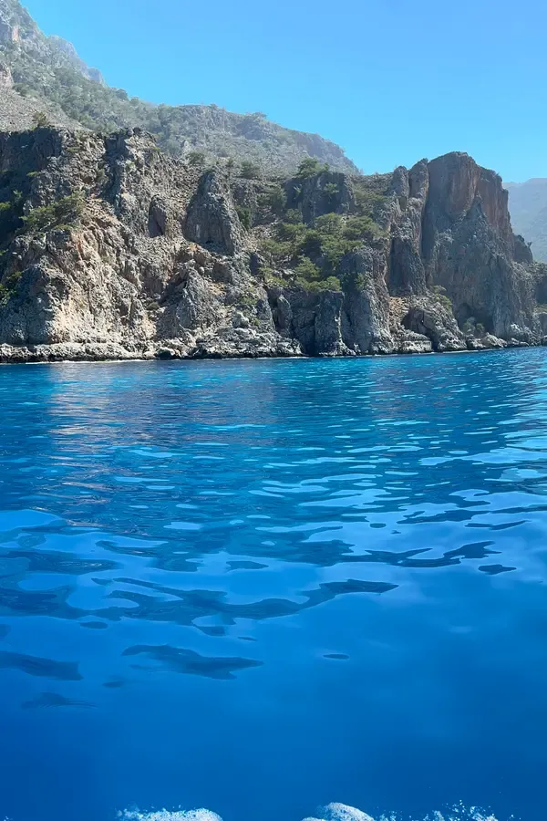 Le village pittoresque de Domata, sur la côte de Crète, offre une vue sur la mer Égée et ses falaises rocheuses.