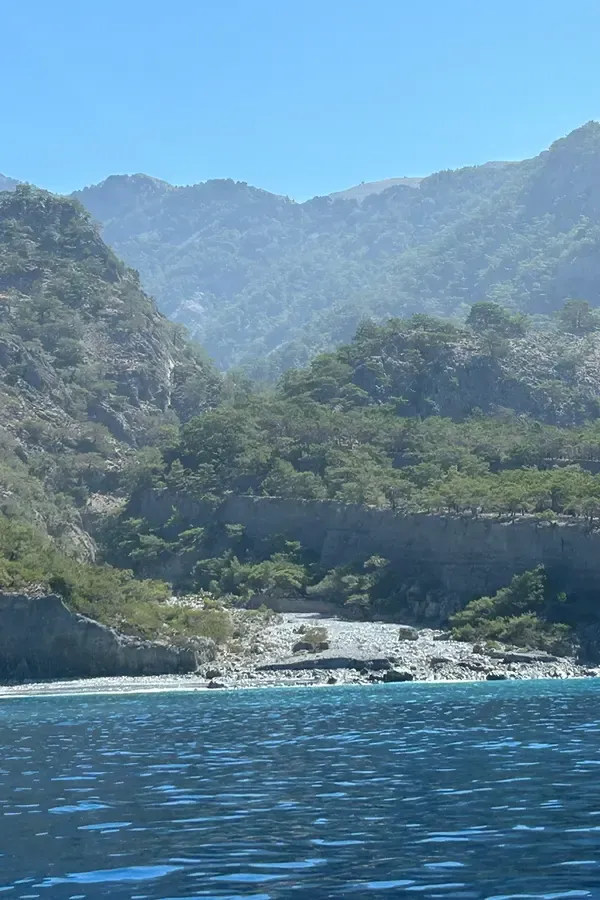 Le paysage côtier de Domata, sur la Crète, montre des falaises escarpées surplombant un lagon d'eau bleu profond.