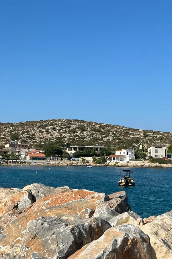 The coastal landscape and village life at Marathi, Crete, viewed from the sea.