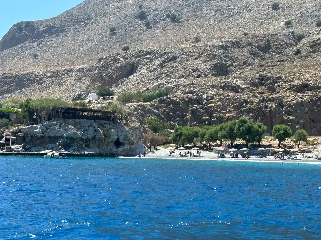 Sentier côtier de Marmara surplombant la mer Égée, dévoilant des falaises escarpées et des eaux d'un bleu profond et cristallin.