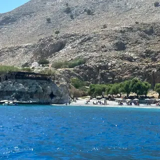 Sentier côtier de Marmara surplombant la mer Égée, dévoilant des falaises escarpées et des eaux d'un bleu profond et cristallin.