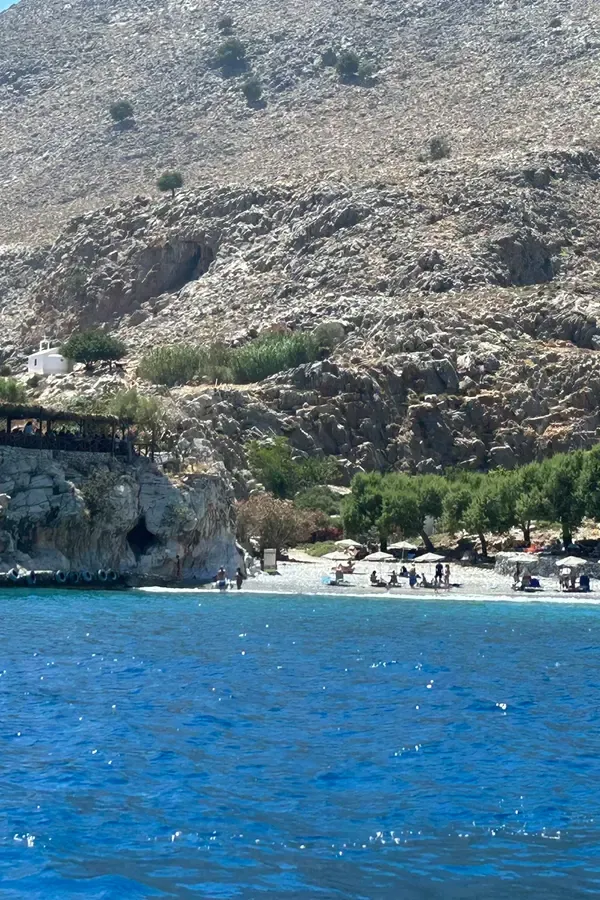 Sentier côtier de Marmara surplombant la mer Égée, dévoilant des falaises escarpées et des eaux d'un bleu profond et cristallin.