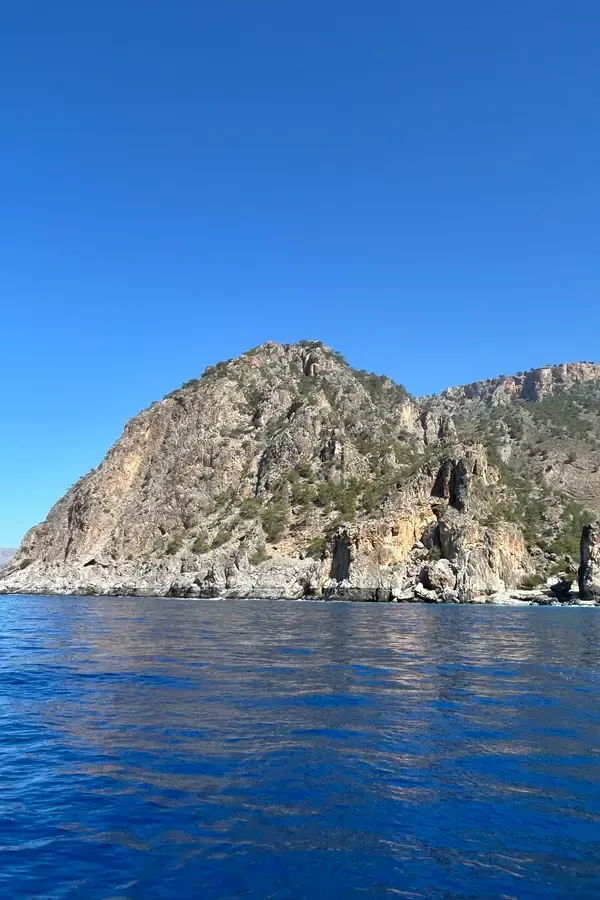 Falaises abruptes et eaux émeraude au cap Tripiti, un reculé joyau sur la côte sud de la Crète grecque.