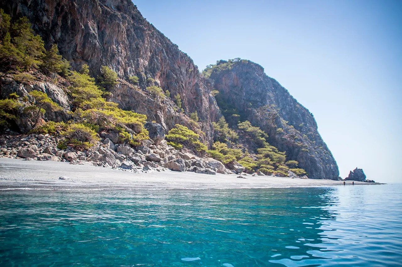 Falaises blanches plongeant dans des eaux turquoise limpides, offrant une vue spectaculaire sur la côte de Candia, Crète.