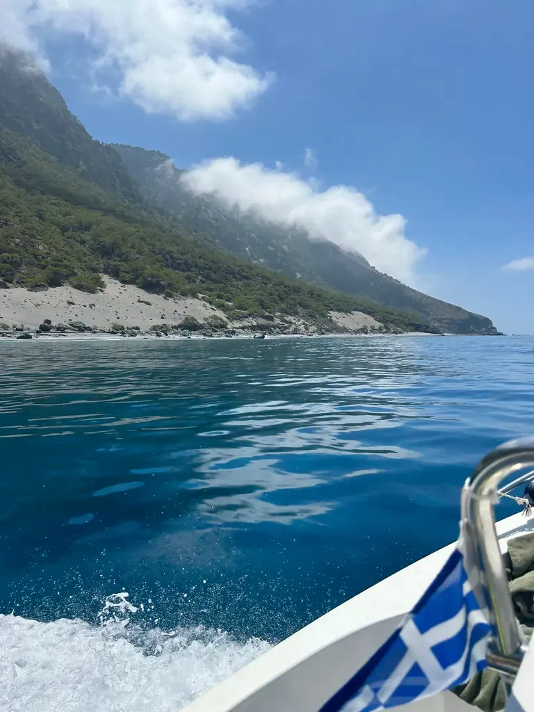 Vue panoramique de la baie d'Agios Pavlos, entre les falaises rocheuses et les eaux turquoise de la mer Égée.