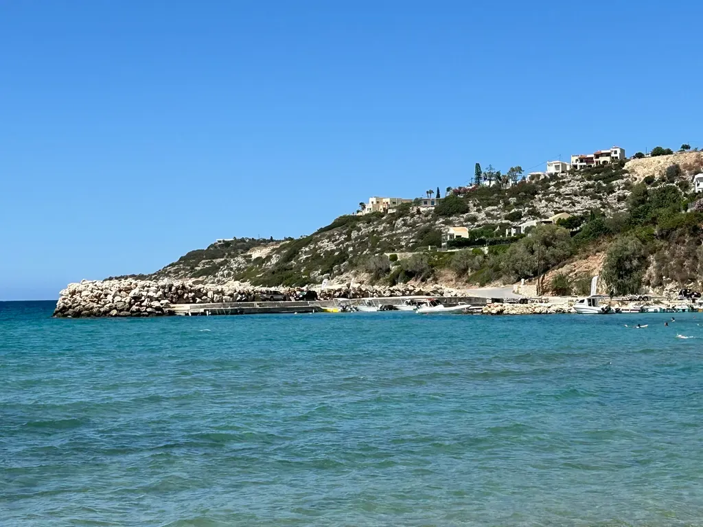 Le pittoresque port d'Almyrida, encadré par des bâtiments colorés et les eaux bleues cristallines de la mer Égée.