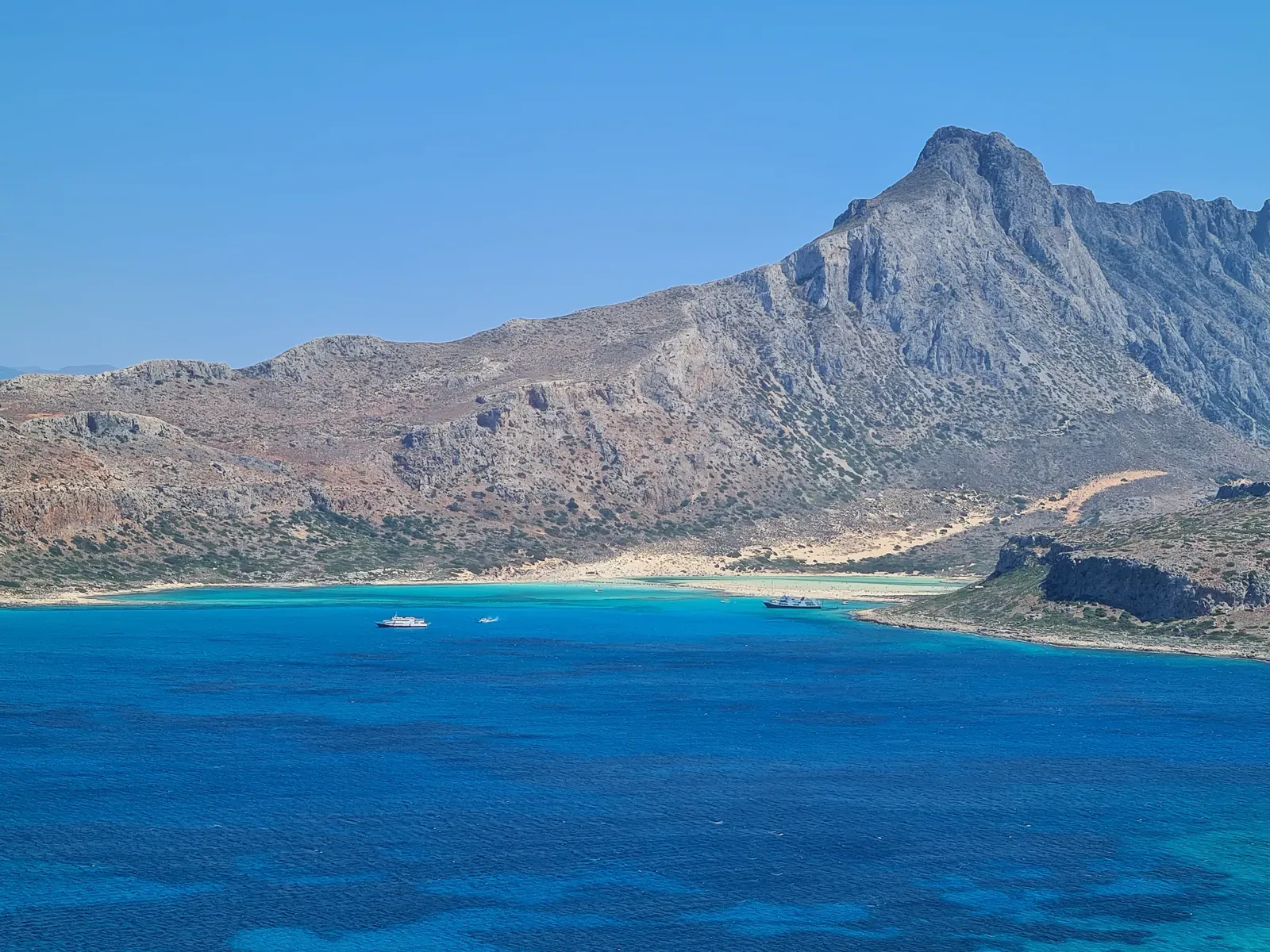 Vastes étendues de sable blanc bordant un lagon turquoise cristallin à Balos, sur la côte ouest de la Crète.