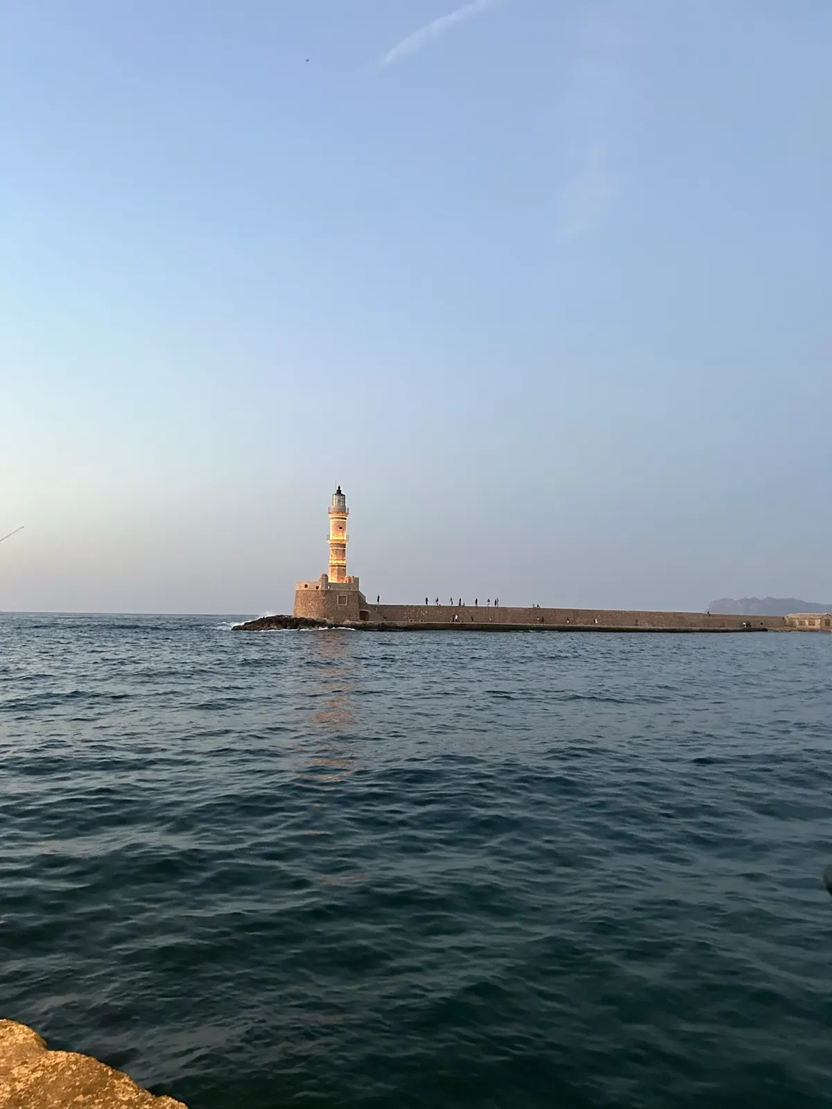 Historic Venetian harbor buildings viewed from the deep blue waters of Chania, Crete.