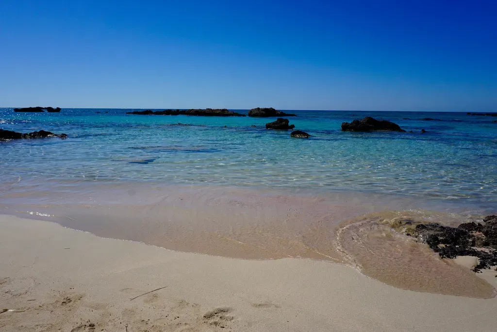 Plage de sable rose emblématique et lagon turquoise peu profond à Elafonissi, un paradis au cœur de la Crète.