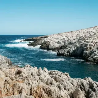 Steep cliffs, turquoise coves, and clear sea characterize Katholiko bay on the western coast of Crete.