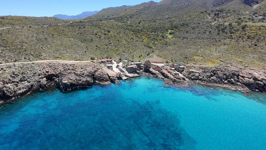 Falaises escarpées et lagon bleu turquoise à Ombrosgialos, une crique isolée offrant un spectacle naturel spectaculaire sur la côte crétoise.
