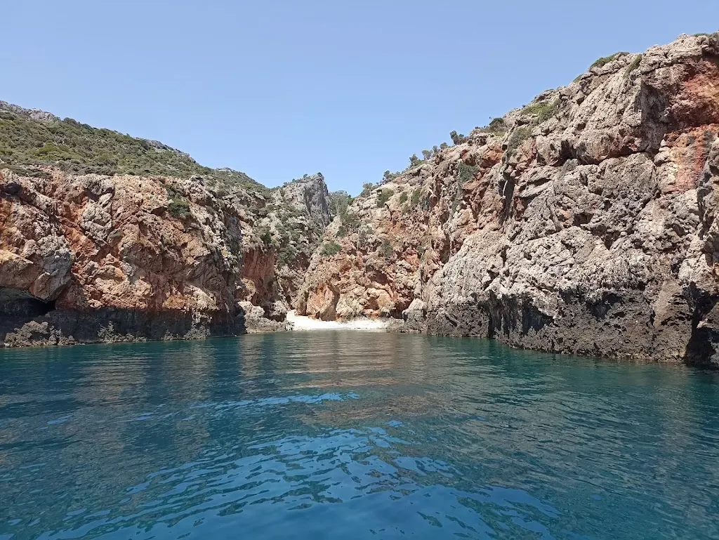 Rugged landscape meeting the calm, deep blue waters at Sfakos beach, Crete.