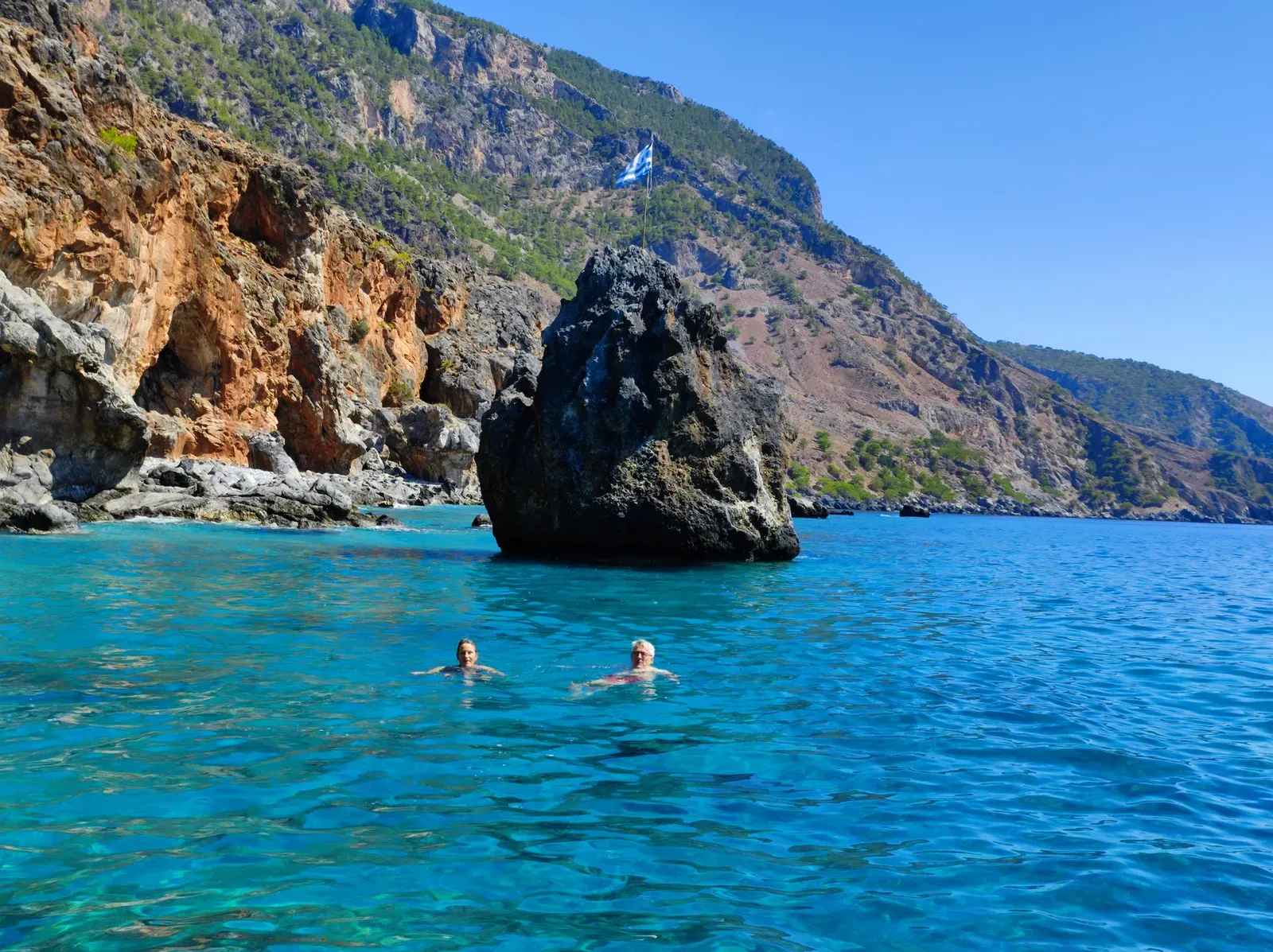 Vue panoramique sur la côte accidentée près de Agios Nikolaos, montrant des eaux cristallines et des falaises calcaires grééques.